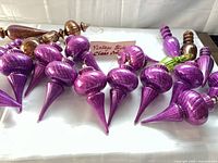 purple, green and copper glass finial ornaments laid out on table