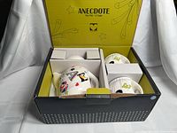 Open box showing teapot and two cups in foam inserts