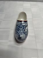 Angled front view of ceramic Dutch clog showing floral and geometric pattern