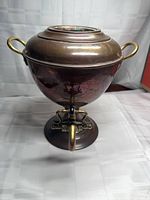 Front view showing lidded sugar bowl, handles, pedestal, spigot