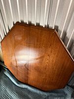 Front view of octagonal wood tabletop leaning against wall