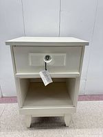 Front view of off-white nightstand showing drawer with glass knob and open shelf