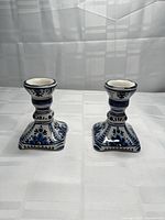 Front view of both blue and white Delft-style ceramic candle holders