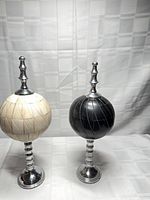 Front view of both finial orb sculptures showing color and pedestal design