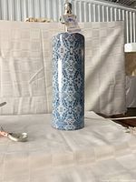 Single lamp showing cylindrical ceramic body with blue pattern and socket