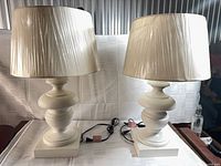 Front view of both white lamps with shades, cords visible