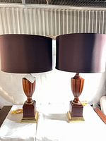 Frontal view of both lamps showing wooden bodies, brass bases, and drum shades