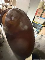 Top view of round hardwood tabletop showing finish clouding