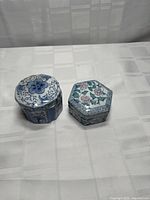 Both lidded hexagonal porcelain trinket boxes closed