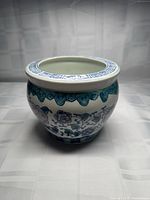 Front view of porcelain planter showing floral motif and Greek key rim