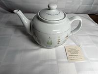 Full view of teapot with lid showing graphics and hang tag