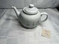 Left side view of Spice of Life ceramic teapot with lid and hang tag