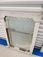 Mirror inside original cardboard packaging showing beveled border design