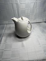 Front/side view of white ceramic teapot with lid fitted