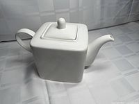Left front view of white square stoneware teapot with lid