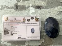 Gemstone beside authenticity certificate showing weight and details
