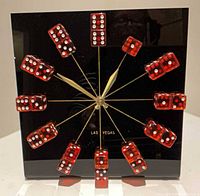 Front view showing red dice hour markers, gold hands, Las Vegas text on black panel
