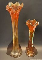 Front view of both marigold carnival glass swung vases showing height difference and iridescent finish