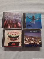 Front covers of Deep Purple, Nirvana, Rolling Stones and Pink Floyd CDs