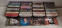 Front view of all 40 cassette tapes stacked showing spines and a few front covers