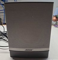 Front view of Bose subwoofer showing silver grille and logo