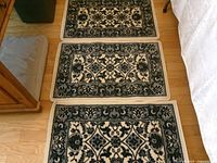 Three matching navy and off-white rugs laid side by side