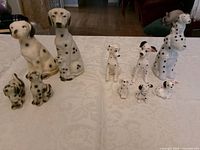All ten Dalmatian figurines displayed on table in two groups