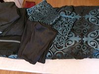 Bedspread with folded sheets and pillowcases on bed