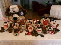 Full group of 11 plush toys and cup on table