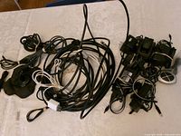 Full lot overview with bundled cables, power adapters, remote, earpiece