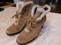 Front angle of both tan suede ankle boots showing lace-up fronts and faux shearling lining