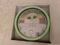 Front view of boxed Grogu wall clock showing design and numerals