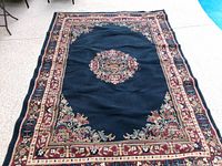 Full view of navy oriental rug showing border and medallion