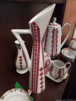Group view showing pitcher, coffee pot, vase, cups, saucers, sugar, creamer