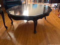 Top view of round dark wood coffee table showing scalloped edge and surface condition
