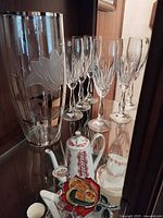 Vase and six crystal flutes displayed in cabinet