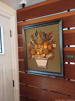 Full view of framed needlework wall art hung on wall