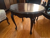full view of round wood table showing top and legs