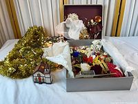 Box of assorted ornaments, tinsel, lights, ceramic house