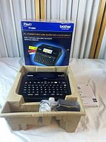 Label maker in pulp tray with accessories and manual