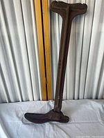 Full view of cast iron cobbler stand showing entire length and shoe last base