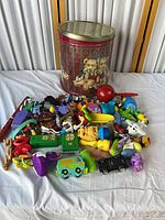 Overview of tin and pile of assorted toys