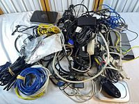 Overview of tangled cables, power adapters, router, mouse