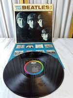 Front cover of Meet The Beatles! sleeve with record and insert
