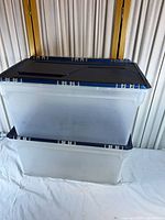 Two stacked clear bins with blue lids