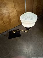 Lamp assembled showing base, brass arm and glass shade
