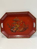 Full view of octagonal red metal tray with handles and painted Asian scene