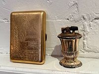 Front view of cigarette case with engraved design and Ronson urn lighter