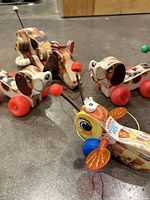 Group view of two Little Snoopys, one Snoopy and Buzzy Bee on concrete floor