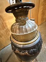 Overall view of lamp showing brass font and cast metal body